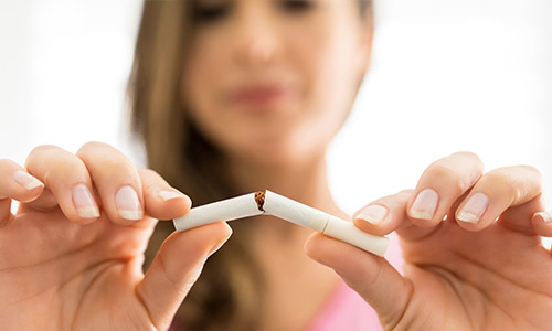 Woman breaking cigarette in half